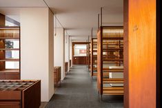 a long hallway with wooden shelves filled with books