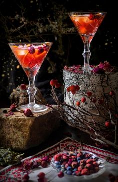 two glasses filled with drinks sitting on top of a table