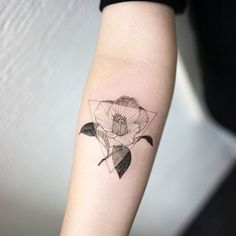 a black and white flower tattoo on the left arm, with an arrow in the middle