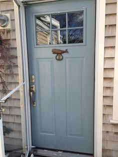 a blue front door with an iron handle and glass pane on the top half