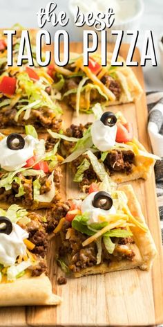 a wooden cutting board topped with pizza slices covered in toppings