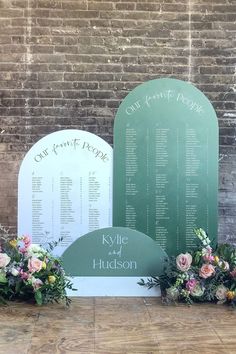 a couple of flowers sitting on top of a wooden table next to a green sign