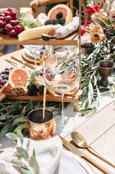 the table is set with cheese, fruit and other food on it's trays