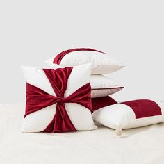 three pillows with red and white bows on them