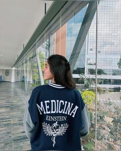 a woman standing in front of a glass wall