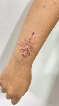 a person with a tattoo on their arm that has the sun and stars in it