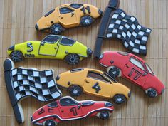 four different colored toy cars sitting on top of a wooden table