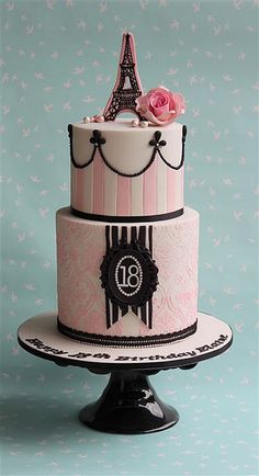 a pink and black cake with the eiffel tower on top