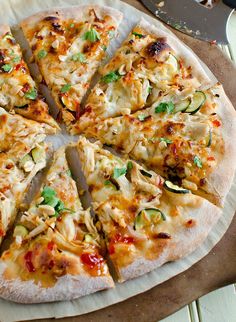 a pizza sitting on top of a wooden cutting board next to a knife and fork