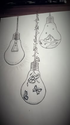 three light bulbs hanging from the ceiling with butterflies on them, and one is drawn in pencil