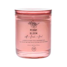 a pink candle with the words peony bloom on it's lid and bottom