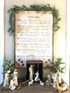 the nativity scene is displayed in front of a large sheet of music and christmas decorations