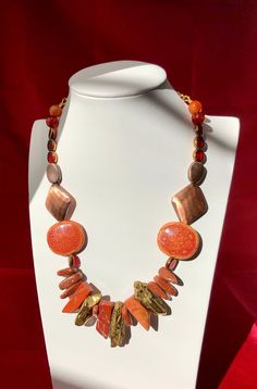 Make your outfit sizzle with this Rustic Flame Necklace. Gold, orange, red hues blend perfectly together. This one of a kind, hand-made necklace is sure to add the perfect amount of glamour to any ensemble. Luxury Handmade Orange Necklaces, Red Long Necklace For Party, Orange Costume Jewelry Necklace For Party, Unique Orange Necklace For Party, Unique Handmade Orange Necklaces, Handmade Unique Orange Necklaces, Bohemian Orange Necklaces With Natural Stones, Handmade Adjustable Orange Necklace, Handmade Orange Necklaces For Party