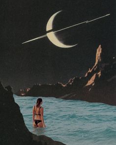 a woman sitting on top of a rock next to the ocean under a crescent moon