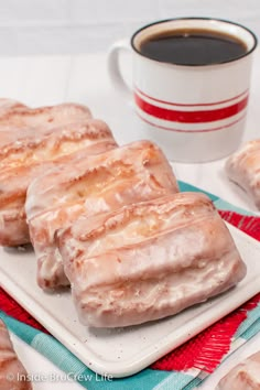 glazed donuts on a plate next to a cup of coffee