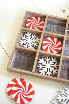 a wooden tray filled with candy canes and snowflakes