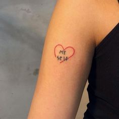 a woman's arm with a small heart tattoo on the left side of her arm