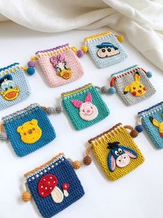 crocheted winnie the pooh coin purses are arranged on a white surface