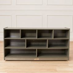 an empty bookcase sitting on top of a hard wood floor next to a white wall