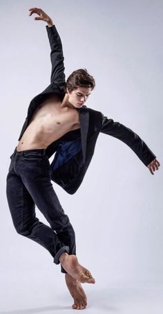 a man in black shirt and jeans doing a trick on a skateboard with one hand