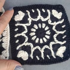 someone is crocheting a square in black and white