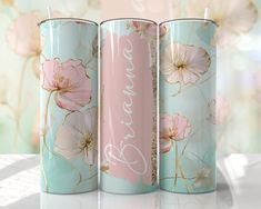 three metal cups with flowers painted on them