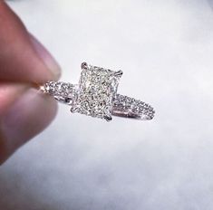 a woman's hand holding a diamond ring