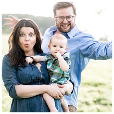 a man and woman holding a baby in their arms