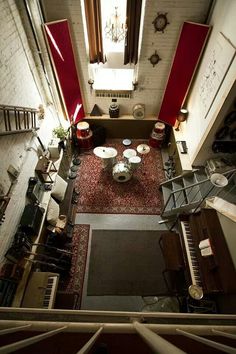 an overhead view of a living room with piano and coffee table in the center, from above