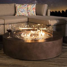 a fire pit sitting on top of a wooden floor next to a couch and table