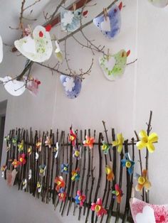 a group of paper flowers hanging from a wall next to a wooden slatted fence