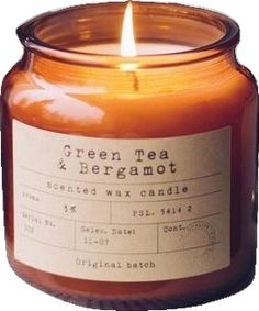 a candle that is sitting in front of a white background with the words green tea and bergamot on it