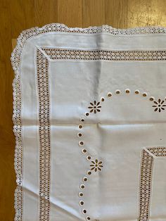 a white table cloth with embroidered designs on it