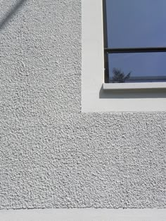 a window on the side of a white building