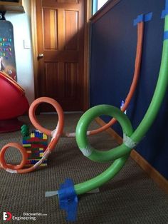 an assortment of toys are laying on the floor in front of a blue wall and door