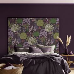 a bedroom with purple walls and a floral headboard on the wall above the bed