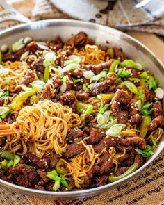 a pan filled with noodles and meat on top of a table