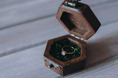 an open wooden box with a wedding ring inside