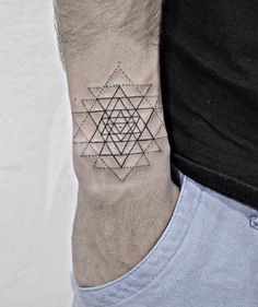 a man's arm with a tattoo on it that has an image of a triangle