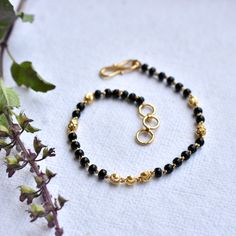 "Single strand gold chain bracelet with black beads and gold balls, handcrafted with love and care, this comfortable bracelet is a perfect accessory for everyday wear. Lightweight and stylish..! * Length : 5.5\" to 9\" + 0.5\" extender eg : 6\" length will fit wrist size of 6\"- 6.5\" * Gold : 18k Solid Yellow Gold * Gold Weight - 2.5 gms approx for 5.5\" inches with extender - For longer/shorter length, please ask for a quote before placing the order. If you like this bracelet, please press \"P Karimani Bracelet For Ladies, Black Bracelet With Gold Beads, Gold Spiritual Beaded Chain Bracelet, Gold Onyx Beaded Bracelets With Round Beads, Gold Onyx Beaded Bracelets With Black Beads, Gold Onyx Beaded Bracelets, Black Beaded Bracelets With Gold Beads For Gifts, Gold Rosary Bracelet With Black Beads As Gift, Spiritual Gold Beaded Bracelet With Black Beads