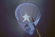 a glass with a white star on it and a wooden stick sticking out of it