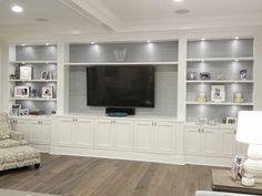 a living room filled with furniture and a flat screen tv mounted to the wall above it