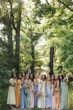 a group of women standing next to each other in front of trees