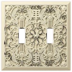 an ornate light switch plate cover with two toggles and one outlet in white