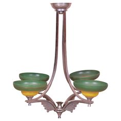 a chandelier with five green and yellow glass bowls hanging from it's arms