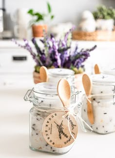 three jars with spoons in them sitting on a counter