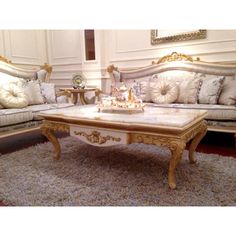 a living room with couches, tables and rugs on the carpeted floor