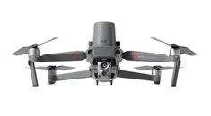 the front view of a grey and orange quadcopter with two propellers on it