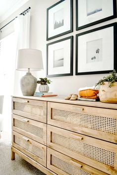 a dresser with pictures on the wall above it