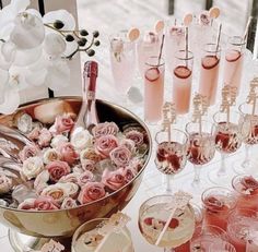 a table topped with lots of glasses filled with pink liquid